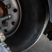 Technician using a power tool to service a truck tire at Big Wheels Repair in Gainesville, illustrating big truck tire services.