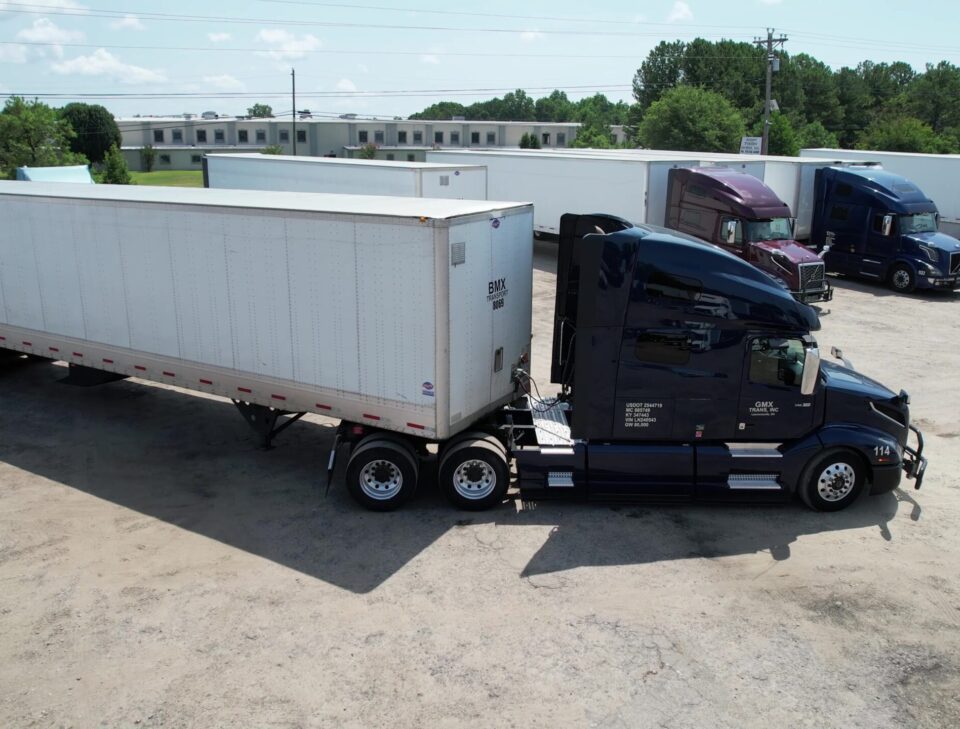 A heavy duty truck parked at Big Wheels Repair in Gainesville, ready for semi-truck maintenance and commercial trailer repair, with other big trucks visible in the background.